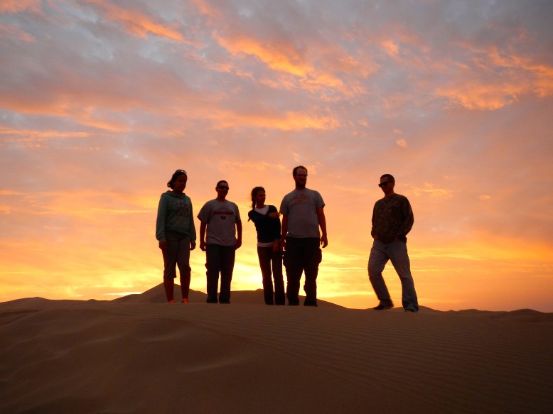 The sun setting over a sand dune in Huacachina.